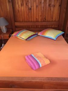 a bed with two pillows on top of it at LE CALBANON in Cilaos