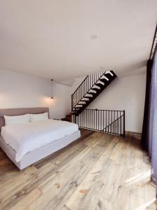 a bedroom with a white bed and a staircase at Rawdon Golf Resort in Rawdon