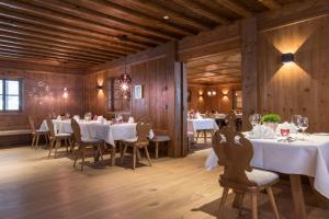 a dining room with white tables and chairs and wooden walls at ElisabethHotel Premium Private Retreat- Adults only in Mayrhofen