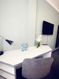 a white desk with a lamp and a chair at Hotel City Kräme am Römer - Self Check In in Frankfurt