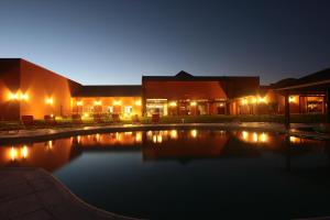 a swimming pool in front of a building at night at Nawan Resort Serrano in Jesús María