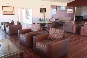 ein Wartezimmer mit Sofas, einem Tisch und Stühlen in der Unterkunft Nawan Resort Serrano in Jesús María