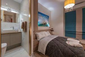 a bedroom with a bed and a bathroom with a sink at Psyche & Eros Mythical Suites in Athens