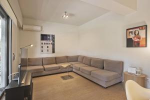 a living room with a couch and a table at Sea Breeze Spacious Apt near Vouliagmeni Beach in Athens
