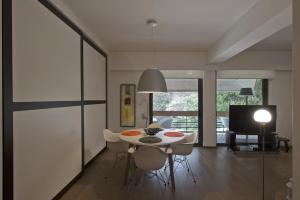 a dining room with a table and chairs and a television at Sea Breeze Spacious Apt near Vouliagmeni Beach in Athens