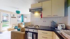 una cucina con fornello forno di livello superiore accanto a un soggiorno di 31 Trevithick Court, Tolroy Manor a Hayle