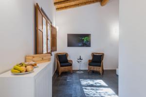eine Küche mit 2 Stühlen und einem Tisch mit Obst darauf in der Unterkunft Terrazze dell'Etna - Country rooms and apartments in Randazzo
