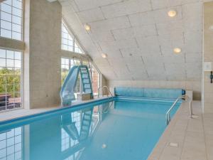 een zwembad met een glijbaan in een gebouw bij Holiday Home Emelita - 900m from the sea in Lolland- Falster and Mon by Interhome in Bøtø By
