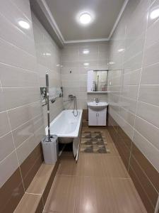 a bathroom with a bath tub and a sink at 3-room apartment on Baytik-Baatyr 37 in Bishkek