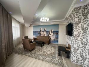 a living room with a couch and a tv at 3-room apartment on Baytik-Baatyr 37 in Bishkek
