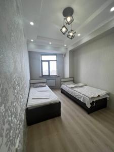 a room with two beds and a window at 3-room apartment on Baytik-Baatyr 37 in Bishkek