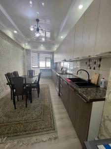 a kitchen and dining room with a table and chairs at 3-room apartment on Baytik-Baatyr 37 in Bishkek