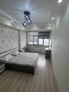 a bedroom with a large bed and a window at 3-room apartment on Baytik-Baatyr 37 in Bishkek