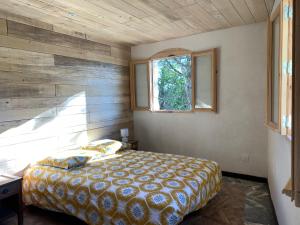 a bedroom with a bed and a window at Grand Gîte Les Cabanes de Fallot pour 19 personnes - piscine naturelle in LʼIsle-Bouzon