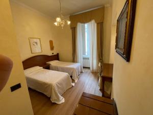 um quarto de hotel com duas camas e uma janela em Le Petit Real em Roma