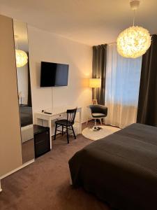 a hotel room with a bed and a desk and a television at Hotel Abtshof in Halberstadt