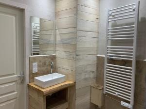 a bathroom with a sink and a mirror at Grand Gîte Les Cabanes de Fallot pour 19 personnes - piscine naturelle in LʼIsle-Bouzon