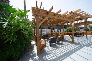 un patio con pergolato in legno, tavolo e sedie. di Days Inn by Wyndham Portland/Corpus Christi a Portland