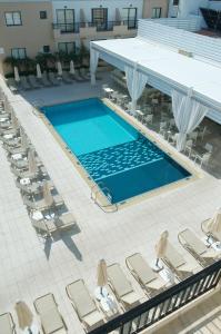 an overhead view of a swimming pool with lounge chairs at Senator Hotel Apartments - Adults Only in Ayia Napa