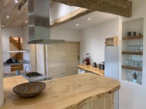 a kitchen with a wooden counter top and a refrigerator at Grand Gîte Les Cabanes de Fallot pour 19 personnes - piscine naturelle in LʼIsle-Bouzon +30 photos