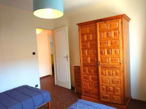 sypialnia z niebieskim łóżkiem i drewnianymi drzwiami w obiekcie 4PA104 Résidence du Port d'Avall w mieście Collioure