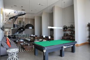 a living room with a pool table and a staircase at Alto del Sol Latorre Mejillones in Mejillones