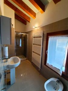 uma casa de banho com 2 lavatórios, um chuveiro e um WC. em Il Nido - Villetta in posizione strategica em Treviso
