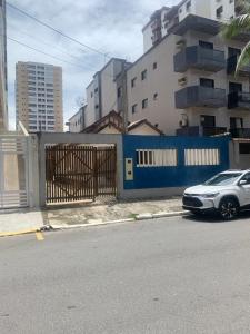 a silver car parked next to a blue fence at Casa Praia Grande in Praia Grande