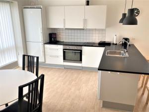 una cucina con armadi bianchi e piano di lavoro nero di Apartment Tolva - 400m from the sea in Funen by Interhome a Rudkøbing