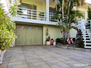 a house with a garage and palm trees at Casa espaçosa próxima ao centro in Encantado