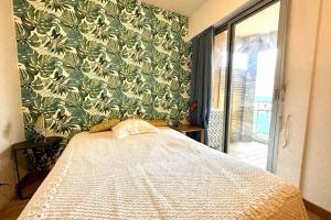 um quarto com uma cama e uma parede verde em Luminous cocoon in the heights of Ajaccio em Ajaccio