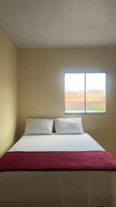 ein großes Bett in einem Zimmer mit Fenster in der Unterkunft Casa Diamantina in Ibicoara