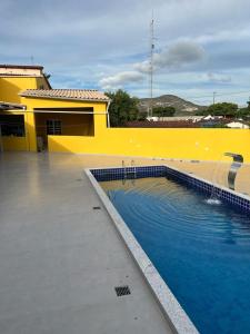 eine Person, die vor einem gelben Gebäude mit einem Pool steht in der Unterkunft Casa Diamantina in Ibicoara
