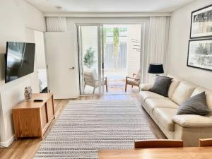 a living room with a couch and a tv at 617 Hastings Street metres to the beach in Noosa Heads