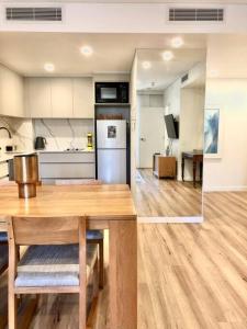 Il comprend une cuisine ouverte et un salon avec une table en bois. dans l'établissement 617 Hastings Street metres to the beach, à Noosa Heads