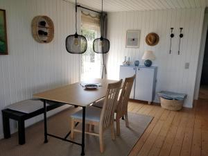 ein Esszimmer mit einem Holztisch und Stühlen in der Unterkunft Holiday Home Silka - 250m from the sea in SE Jutland by Interhome in Augustenborg