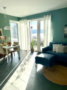 un soggiorno con divano blu e tavolo di Feriendomizil Möhne mit Seeblick und Sauna a Möhnesee