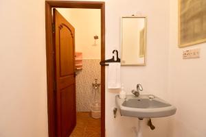 a bathroom with a sink and a toilet and a mirror at Villa Felicia in Puducherry