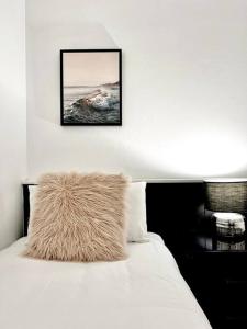 Una cama blanca con una almohada peluda encima. en 225 2 Bedroom Garden Oasis French Quarter Resort en Noosa Heads