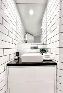Baño blanco con lavabo y espejo en 225 2 Bedroom Garden Oasis French Quarter Resort en Noosa Heads
