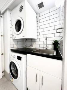 een witte wasruimte met een wastafel en wasmachines bij 225 2 Bedroom Garden Oasis French Quarter Resort in Noosa Heads