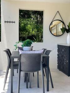 einen Esstisch mit Stühlen und einem Spiegel in der Unterkunft 225 2 Bedroom Garden Oasis French Quarter Resort in Noosa Heads