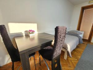 a dining room with a table and chairs with a bed at Hostel Center in Sarajevo