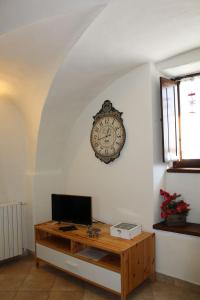 a clock hanging on a wall with a desk at Casa Griot in Pragelato
