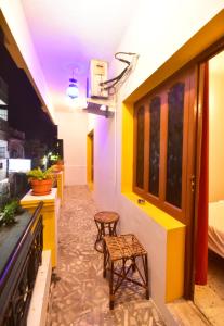 a room with two stools and a room with yellow and white walls at Villa Felicia in Puducherry