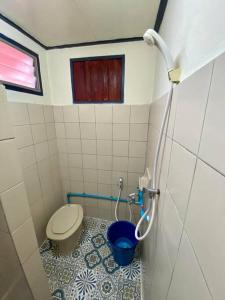 a bathroom with a toilet and a blue bucket at Ratanawong Place 552 in Bangkok