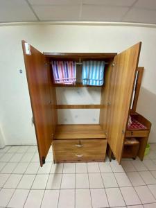 einem Holzschrank auf einem Fliesenboden in der Unterkunft Ratanawong Place 552 in Bangkok