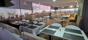 a restaurant with tables and chairs in a room at Hotel Swani in Meknès