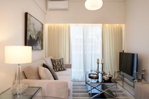 a living room with a couch and a tv at La Residence Athens in Athens