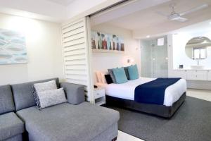 1 dormitorio con 1 cama y 1 sofá en 124 Hastings Street 2 bedroom walk to the beach, en Noosa Heads